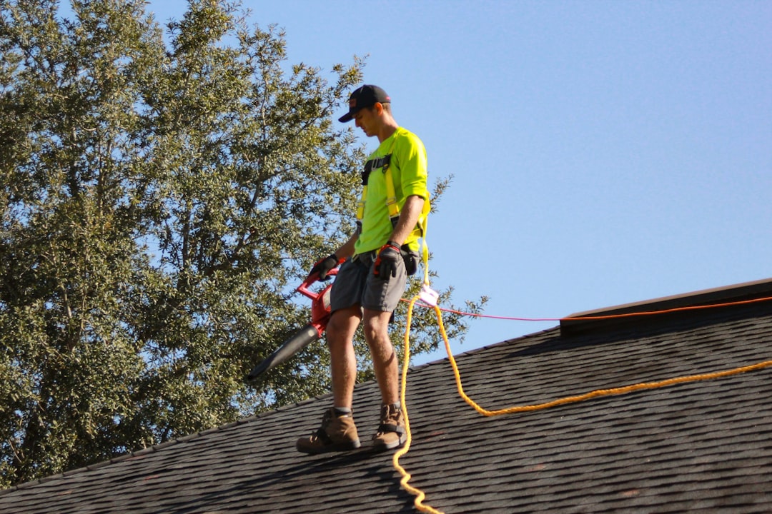 services-03 a-man-in-a-yellow-shirt-with-a-chainsaw-on-a-roof-q2iyhjrmtxu